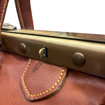 dettagli occhiello chiusura con lucchetto su struttura in ferro metallo atlante bagaglio classico in cuoio borsa da lavoro e viaggio con rinforzo in metallo fatta a mano in pelle marrone made in italy cuoieria italiana®