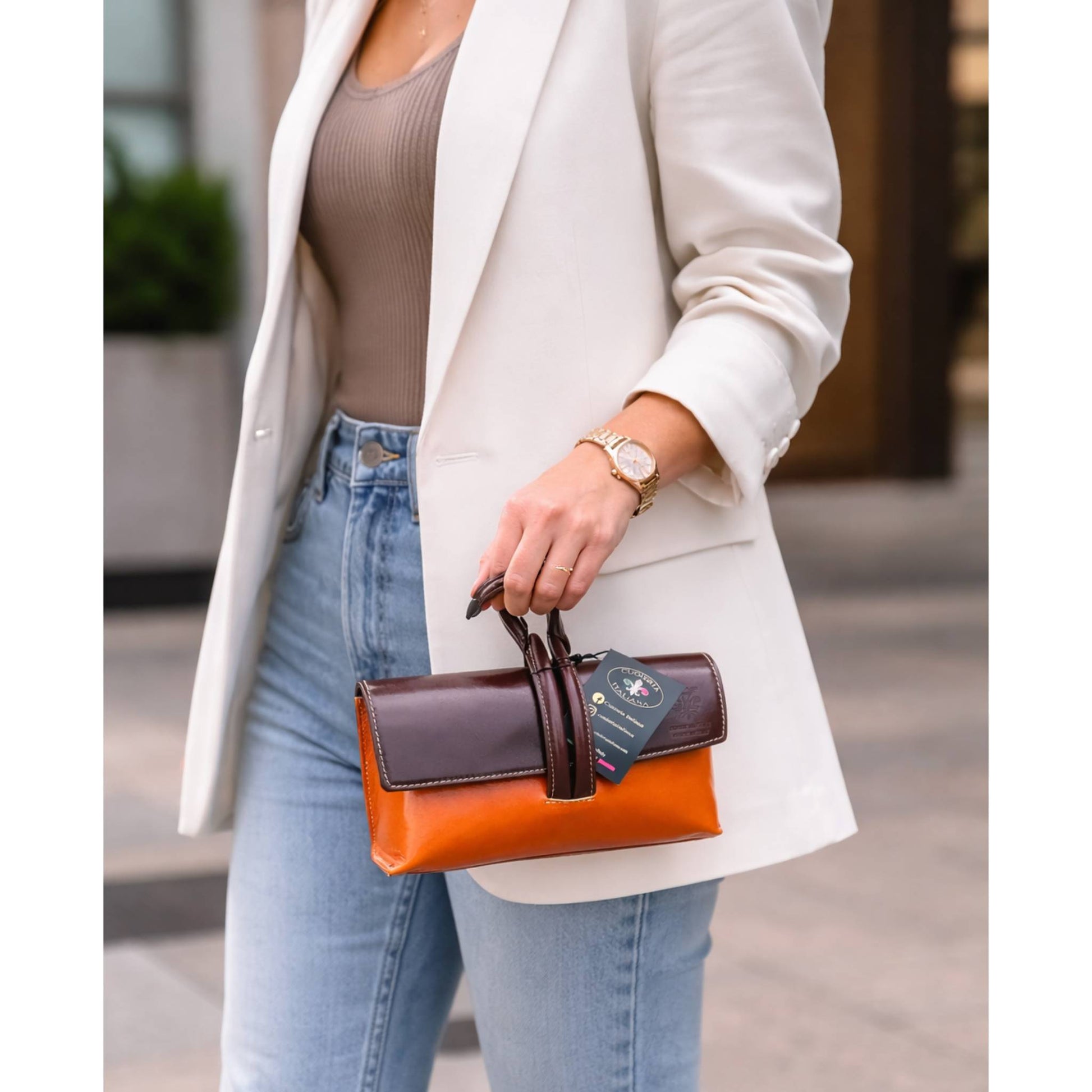 modello a mano fiocco pochette borsetta a tracolla in pelle arancione e marrone made in italy cuoieria italiana